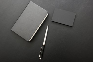 Laptop, akıllı telefon ve bir fincan kahveli diğer iş malzemeleri olan siyah masa ofisi. Metni kopyalamak için üst görünümü kullan. Desenci çalışma alanı düz masa üzerinde temel elementler yatıyordu