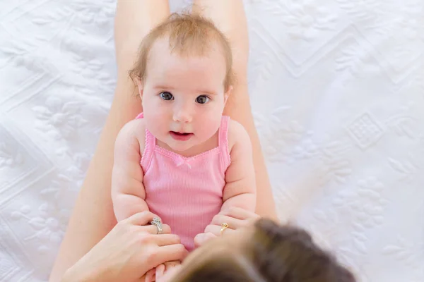 可爱的好奇4个月大的女婴休息在她妈妈的圈主演在相机 — 图库照片