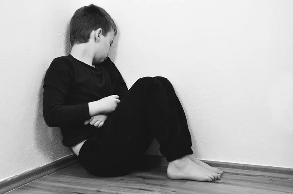 小さな虐待家庭内暴力のための彼の家の隅に叫ぶ少年 — ストック写真