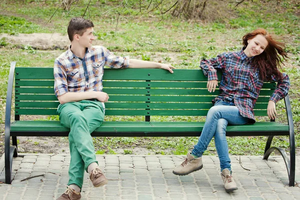 Flirten jonge paar op een bankje — Stockfoto