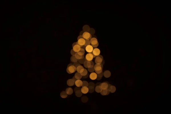 暗い背景に金色のフレアを輝くクリスマス ツリー点灯ボケ — ストック写真