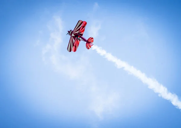 プロペラは青空に尾に白い煙を上方飛んで赤い飛行機 — ストック写真