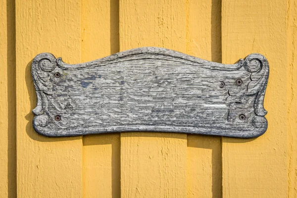 太阳下黄色木板墙上的木制复古标志 — 图库照片