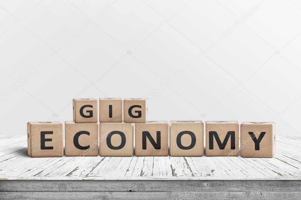 Gig economy sign made of wood on a worn table with white painted planks