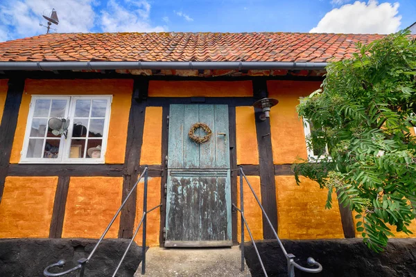 Ingresso di una vecchia casa arancione sotto un cielo blu — Foto Stock