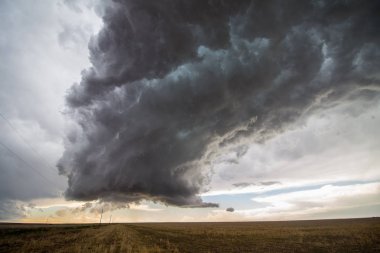 A supercell thunderstorm towers over the landscape of the Great Plains. clipart