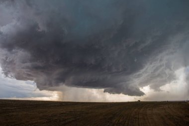 A supercell thunderstorm develops a wall cloud and begins to rotate over the plains of eastern Colorado. clipart