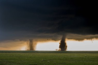 Two tornadoes touch down simultaneously in the plains of eastern Colorado, a rare and spectacular weather event. clipart