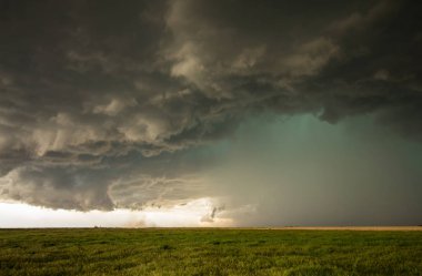 A dangerous supercell storm containing torrential rain and large hail emits a green glow in the sky. clipart