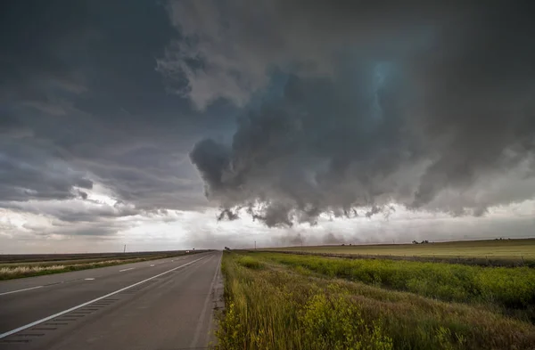 暗い嵐雲から厳しい風が平野部に高速道路の汚れを吹き飛ばす — ストック写真