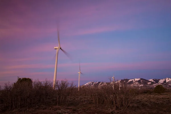 Wind Turbines Spinning Sunrise Mountains Distance Pink Clouds Sky — Stock Photo, Image