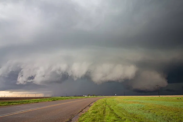 棚の雲と壁の雲を持つ大きなスーパーセルの嵐は 田舎の道路の上に迫っています — ストック写真