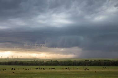 Bir Supercell fırtına, uzak bir rüzgar çiftliği tarafından ovalarda toz üflemek rüzgarlar oluşturur.