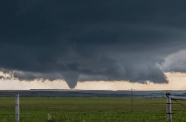 Wyoming ovalarında karanlık bir fırtınanın tabanı altında büyük bir koni kasırga.