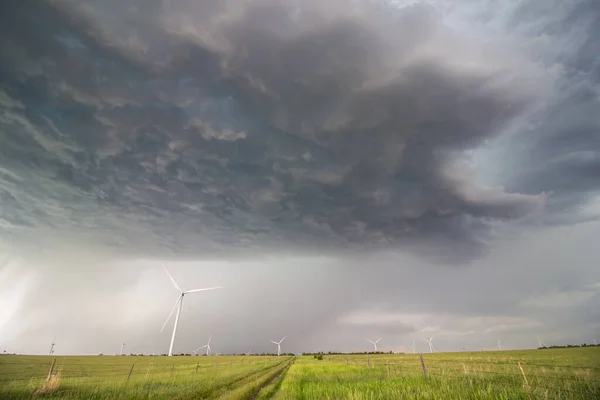 草原の風力タービンの上のスーパーセル雷雨の暗い基盤 雨は遠くに降る — ストック写真