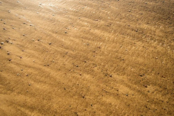 Песчаный пляж с мелким серфингом и галькой — стоковое фото