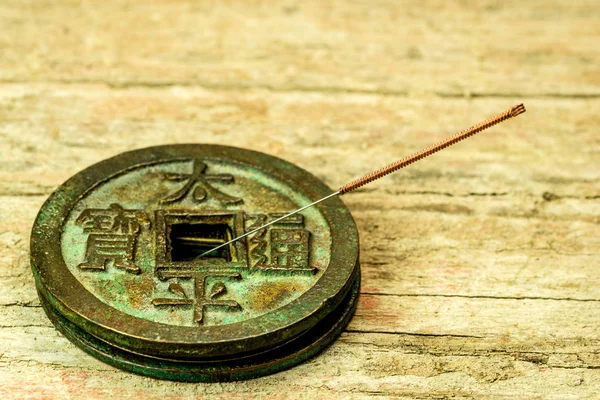 Acupuncture needle on antique Chinese coin — Stock Photo, Image