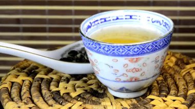 bir Çin kase ve kaşık bir dönüş tablo üzerinde kurutulmuş Barutun Yasemin çayı