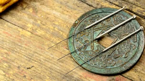 针刺针在古色古香的中国硬币和人参根 — 图库视频影像