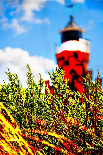 Leuchtturm mit grünen Pflanzen und blauer Himmel mit Wolken — Stockfoto