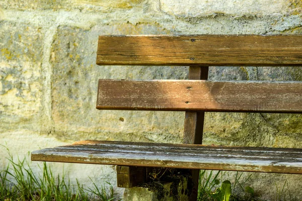 Park bench at an old antique abbey wall — Stock Photo, Image