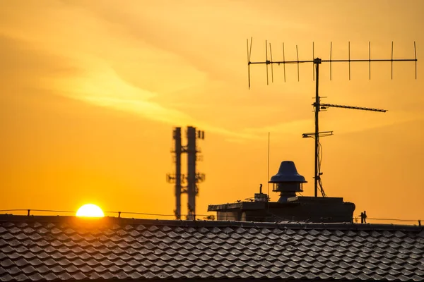 Alba in una città con tetto della casa e antenna — Foto Stock