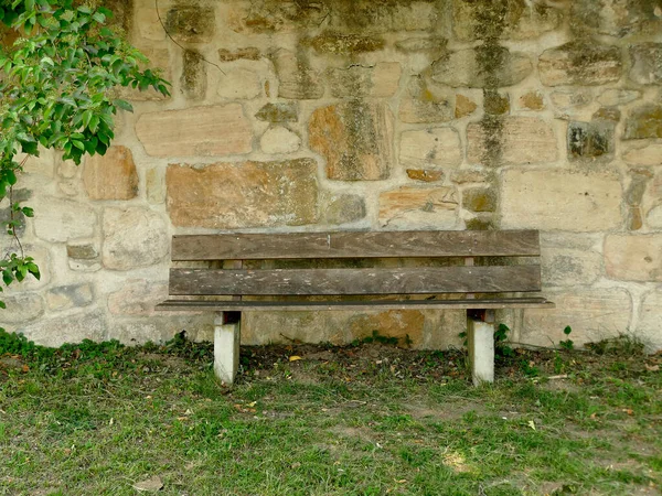 park bench at an old antique abbey wall