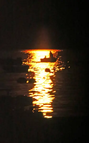 sunset over the Mediterranean Sea with boat and fishermen