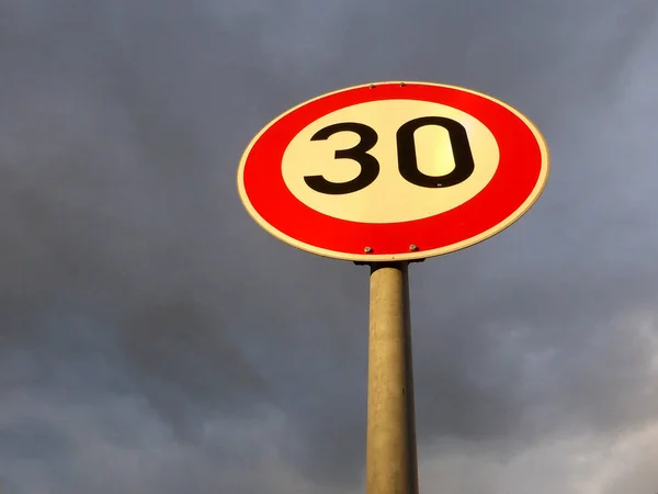 Traffic sign in Germany at a dark sky with speed limit 30 — Stock Image Traffic Sign Germany Dark Sky Speed Limit Royalty Free Stock Images
