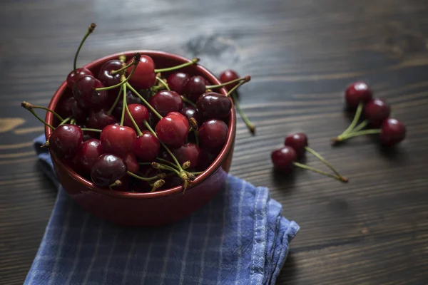 Třešně a višně. Cherry. Třešně v barevné mísy a kuchyňské ubrousky. — Stock fotografie