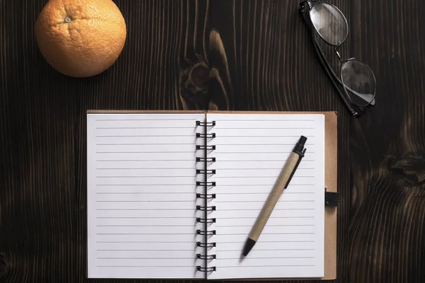 Blanco Notebook Oranje Fruit Een Bureau Van Bovenaf — Stockfoto