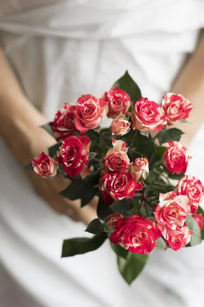 Woman holding bouquet of pink small roses — Stock Photo, Image