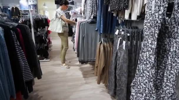 Femme Shopping Look Sur Les Robes Sur Cintres Dans Boutique — Video