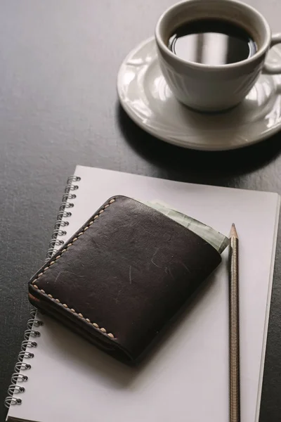 Schwarzer Schreibtisch Mit Kaffee Portemonnaie Papier Und Stift Nahaufnahme — Stockfoto