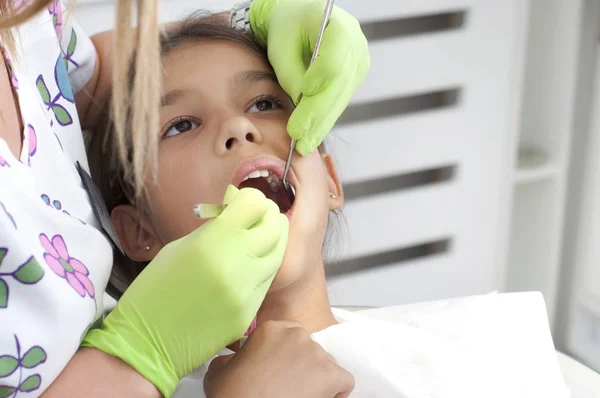 Child visits the dentist, sitting in his chair and opened her mouth for examination of the teeth