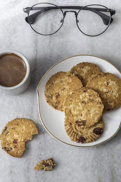 Chocolate chips cookies and coffee, shot from above on a white marble background