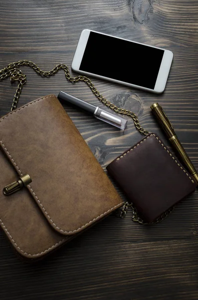 Inhoud van de tas van de vrouw op de houten achtergrond — Stockfoto