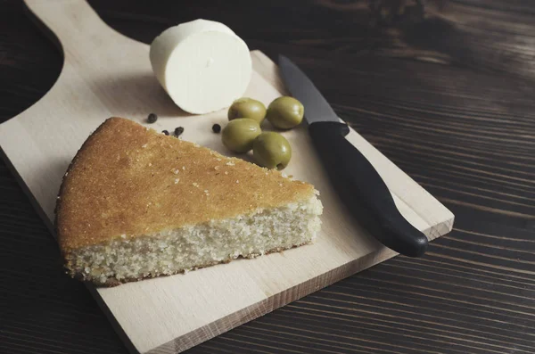 Hausgemachtes Maisbrot mit Käse und Oliven auf dem Tisch — Stockfoto