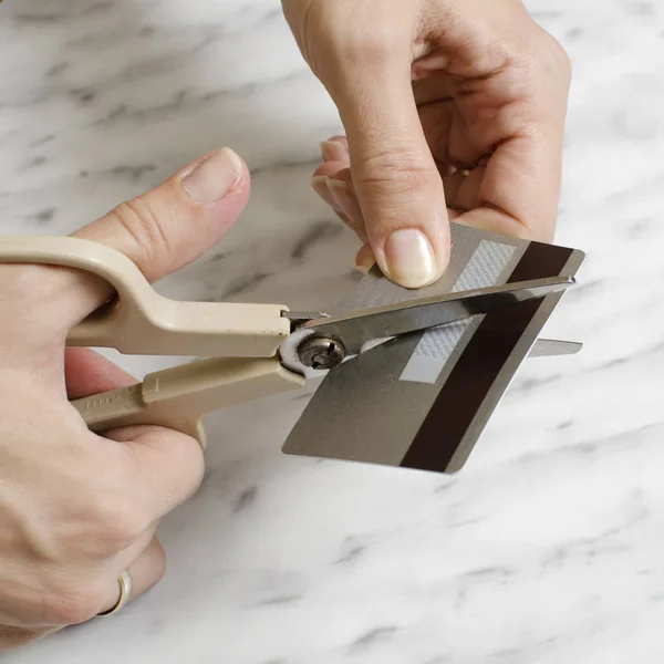 Ženské ruce řezání kreditní kartu s nůžkami — Stock fotografie