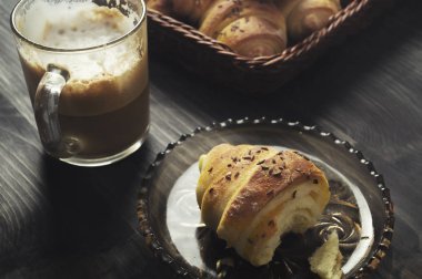Ev yapımı çörekler ve ahşap masada kahve.