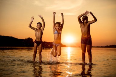Üç çocuk dışarıda eğleniyor. Yaz tatili ve dostu aile kavramı