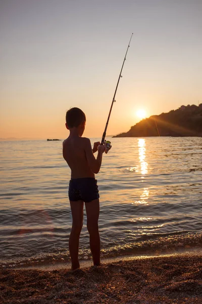 Jongen Vissen Branding Van Oceaan Bij Zonsondergang — Stockfoto