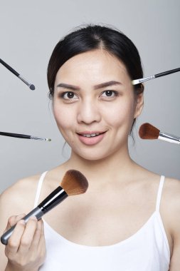 Güzellik Asyalı kadın portre kozmetik makyaj fırçaları yüz, kız moda Model yakınındaki ile. Mükemmel cilt. Shot kamera stüdyoda arıyorsunuz