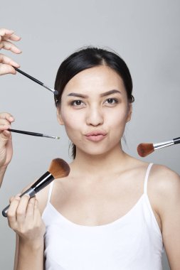 Güzellik Asyalı kadın portre kozmetik makyaj fırçaları yüz, kız moda Model yakınındaki ile. Mükemmel cilt. Shot kamera stüdyoda arıyorsunuz