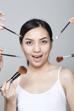 Güzellik Asyalı kadın portre kozmetik makyaj fırçaları yüz, kız moda Model yakınındaki ile. Mükemmel cilt. Shot kamera stüdyoda arıyorsunuz