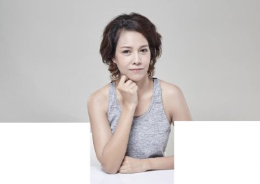 Boş bir masa, boş afiş fikirler ile genç güzel Asyalı kadın