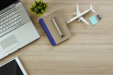 Office not defteri ve uçak, bilgisayar ve ağaç ahşap masa. kopya alanı tasarımı için en iyi manzaralı. düz lay