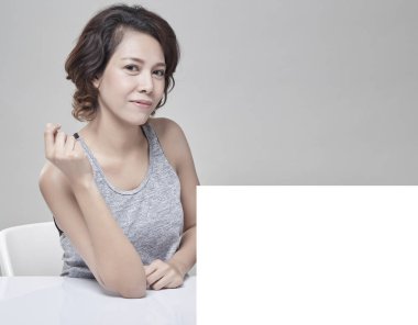 Boş bir masa, boş afiş fikirler ile genç güzel Asyalı kadın