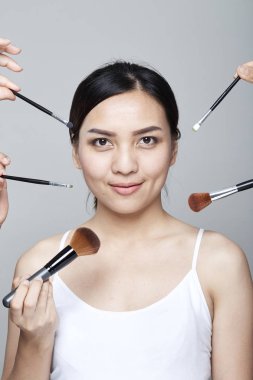 Güzellik Asyalı kadın portre kozmetik makyaj fırçaları yüz, kız moda Model yakınındaki ile. Mükemmel cilt. Shot kamera stüdyoda arıyorsunuz