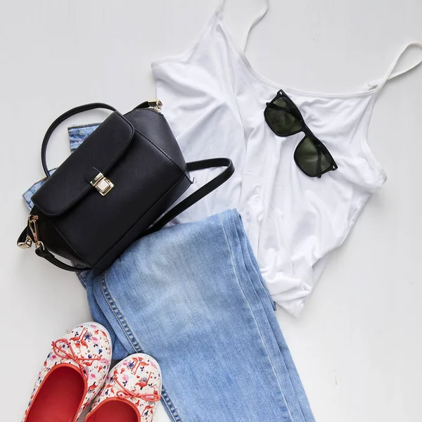 jean, güneş gözlüğü, küpe Beyaz ahşap masa arka plan ile düz yatıyordu kadınsı kıyafetler ve aksesuarlar kolaj